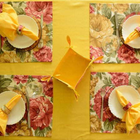 Жълта покривка и салфетки аранжирани за четири човека