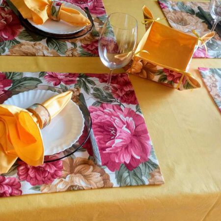 Подредена маса за четири човека с подложки за сервиране, салфетки и прибори