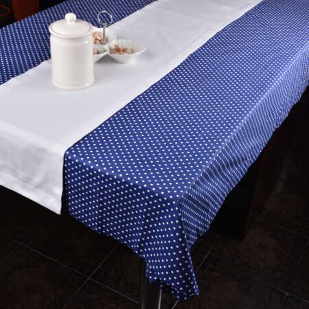 Комплект от тъмно синя покривка на бели точки и бял тишлайфер аранжирани с бяла захарница и купа за ядки