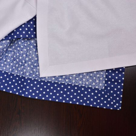 Опакова страна и завършване на ъгъл на тъмно синя покривка и бял тишлайфер