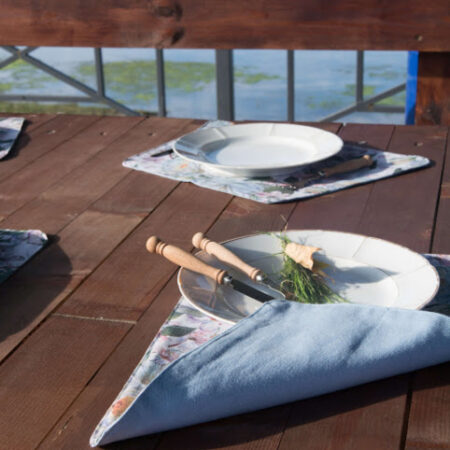 дървена маса, платнени подложки за хранене, чинии и прибори