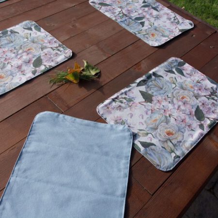 Дървена маса с подложки за хранене в синьо и десен на цветя
