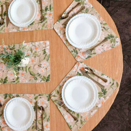 Част от овална маса аранжирана с подложки за хранене, чинии, прибори и декорация