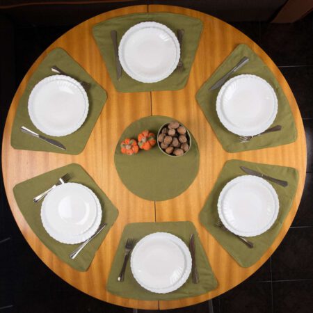 Кръгла маса със зелени подложки за хранене, чинии и декорация
