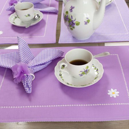 кафе в красива чаша и аранжирано с лилава покривка