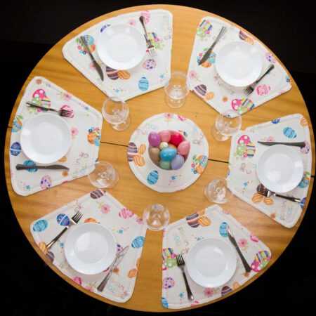 кръгла маса аранжирана с комплект великденски подложки за хранене