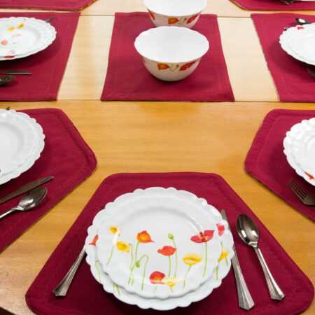 овална маса с правоъгълни и трапецовидни подложки за хранене в червено