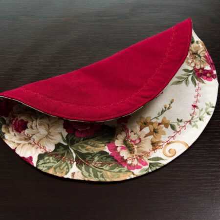 две лица на кръгла подложка за хранене с червени рози на тъмна маса