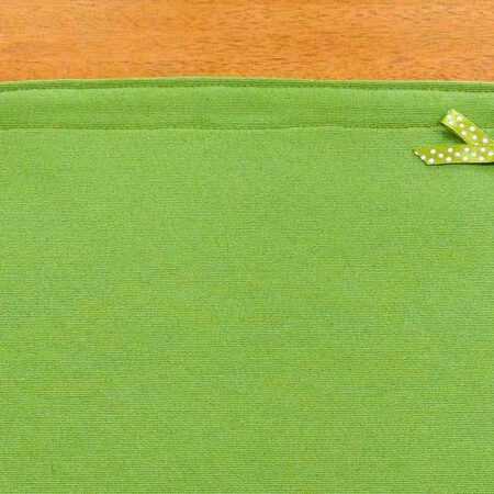 детайл с дискретна зелена панделка от едната страна на двулицеви подложки за хранене