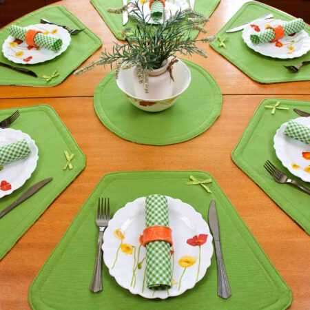Кръгла маса аранжирана със зелени подложки за хранене