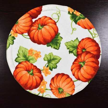 Кръгла подложка за хранене в шарка на оранжеви тикви на тъмна маса