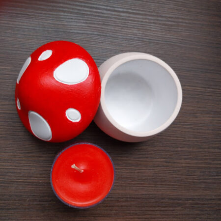 Малка червена гипсова гъбка за декорация и червена свещ