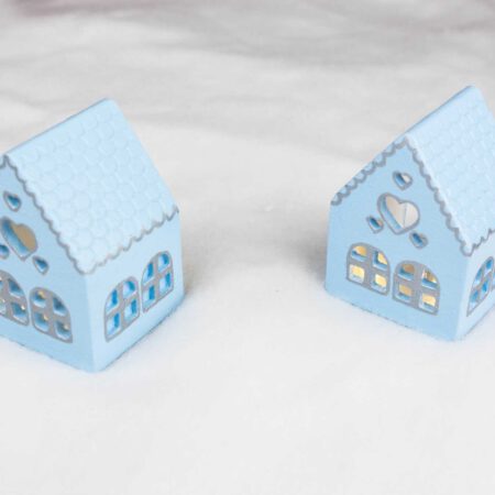 Малки сини къщички в снега със сребристи орнаменти