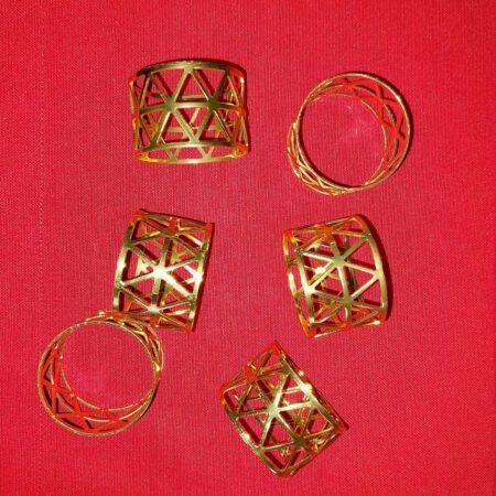 Златисти рингове за салфетки на червена покривка